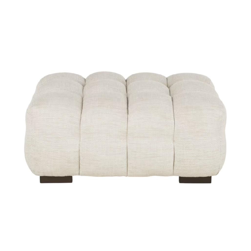 Pouf en tissu beige avec rembourrage capitonné.